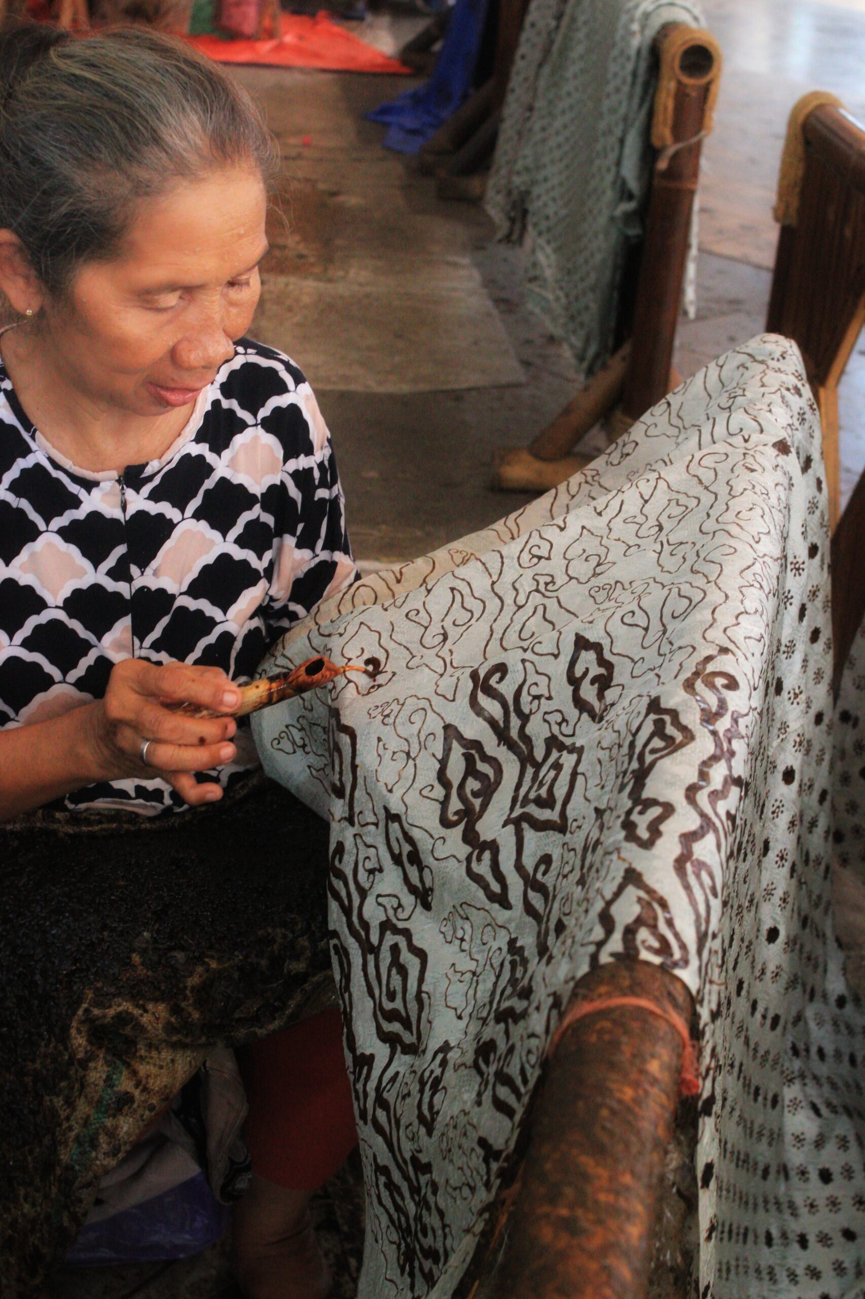 Perajin sedang membatik dengan canting di Trusmi Cirebon